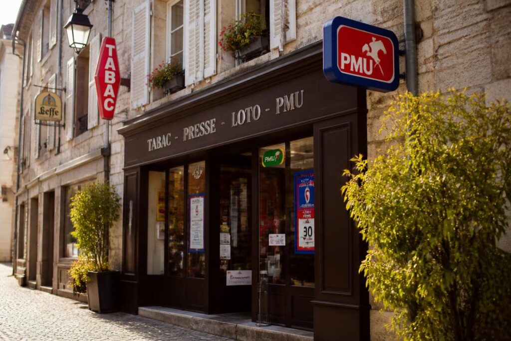 Devanture bureau de tabac PMU village français avec enseigne rouge et bleue PMU